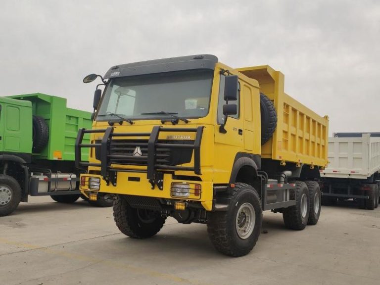 Желтый самосвал HOWO 6X6, припаркованный на стоянке, демонстрирует мощную переднюю решетку и фары с защитной решеткой.